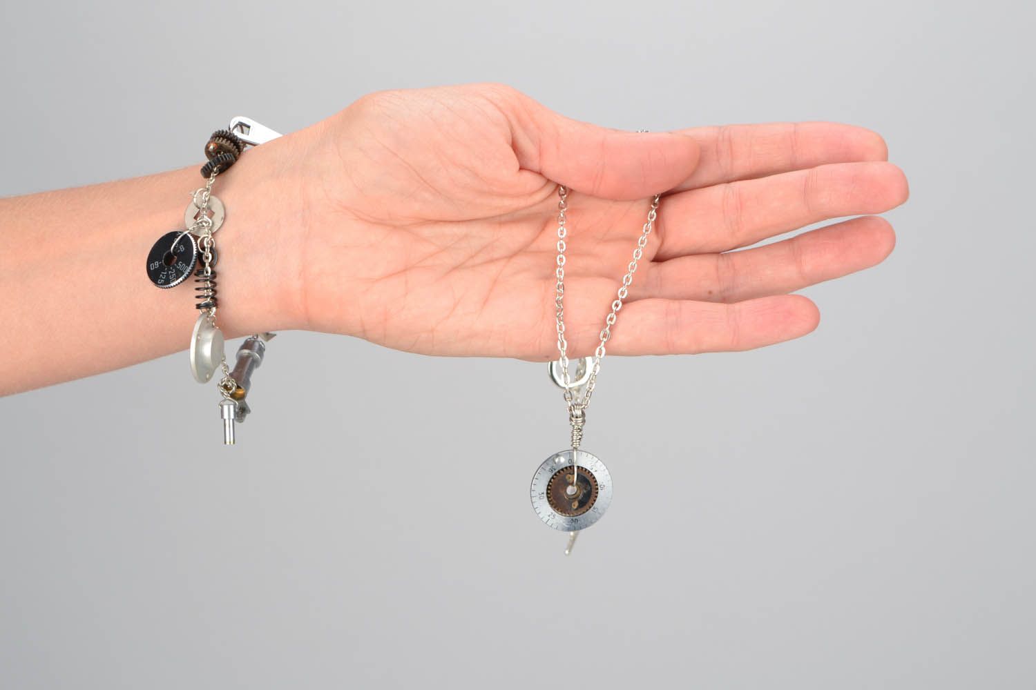 Conjunto de jóias com mecanismos pulseira e pingente numa corrente foto 2