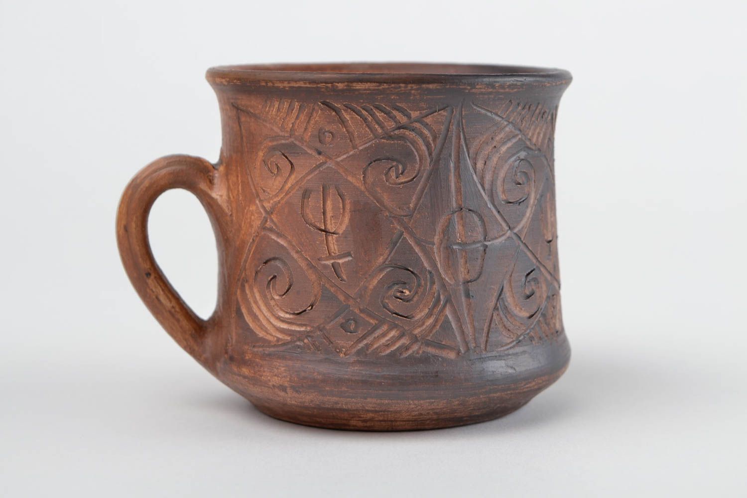 Clay cup for drinks in brown color with handle and cave symbols photo 3