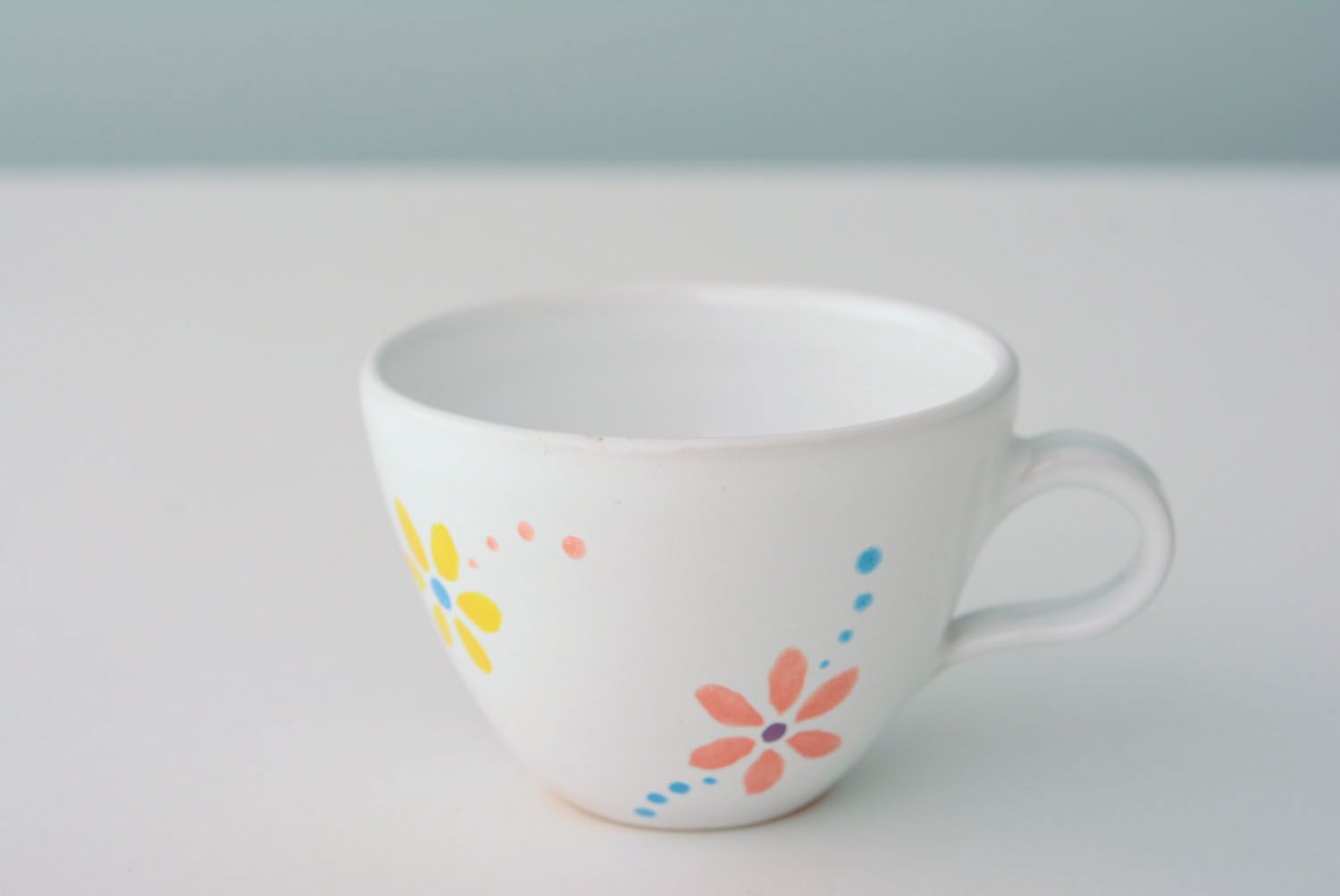 White ceramic drinking handmade 5 oz cup with handle and orange-blue flowers' pattern photo 1