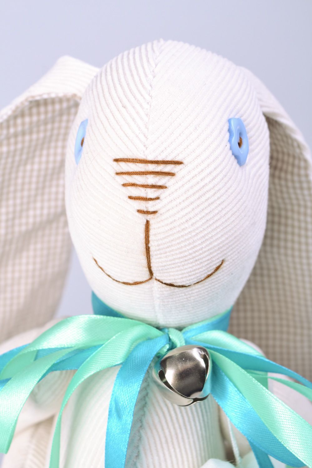 Handmade designer soft toy rabbit sewn of fabric of white color with blue bow photo 4