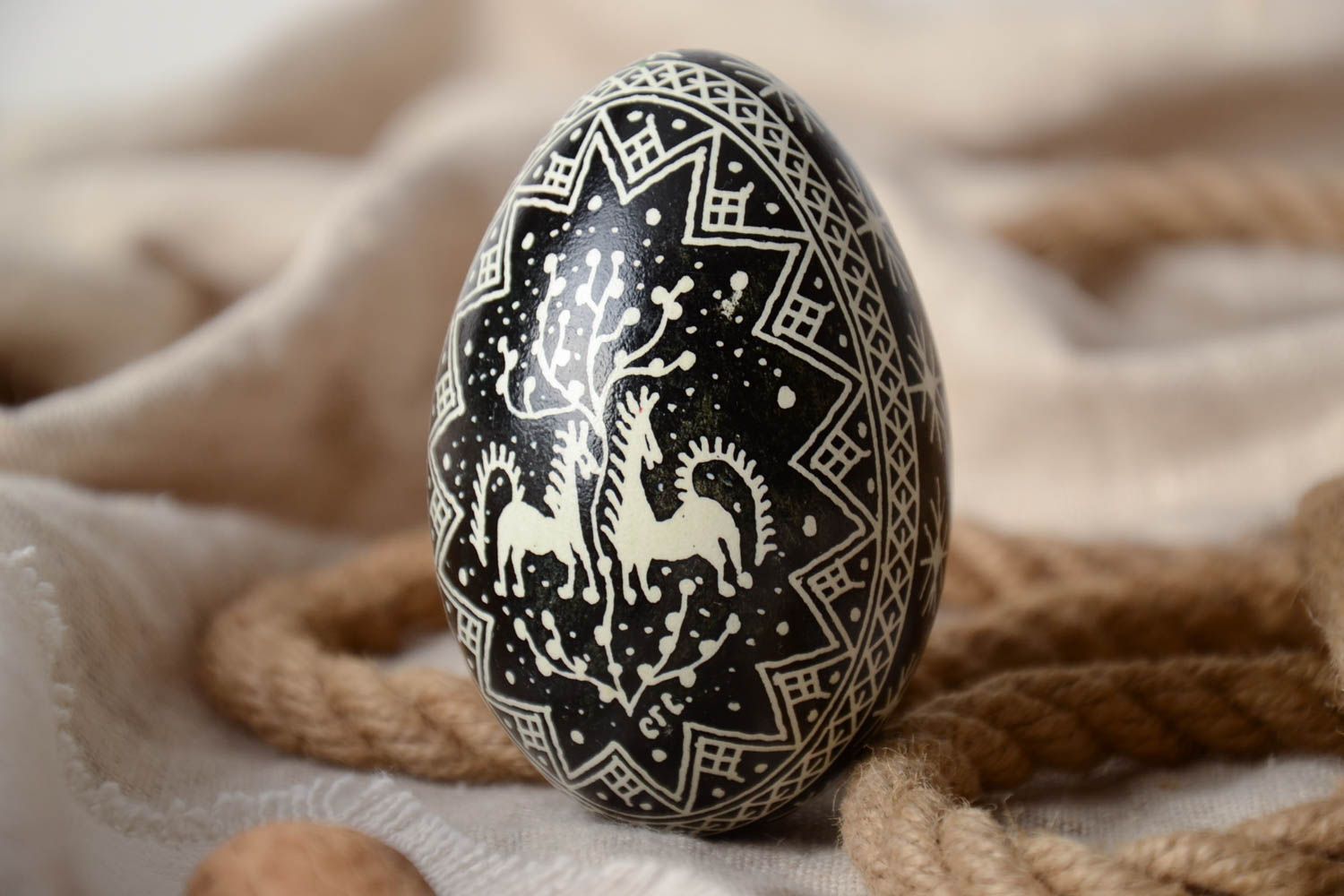 Huevo de ganso de Pascua artesanal blanquinegro con imágenes de caballos y pintura con cera foto 1