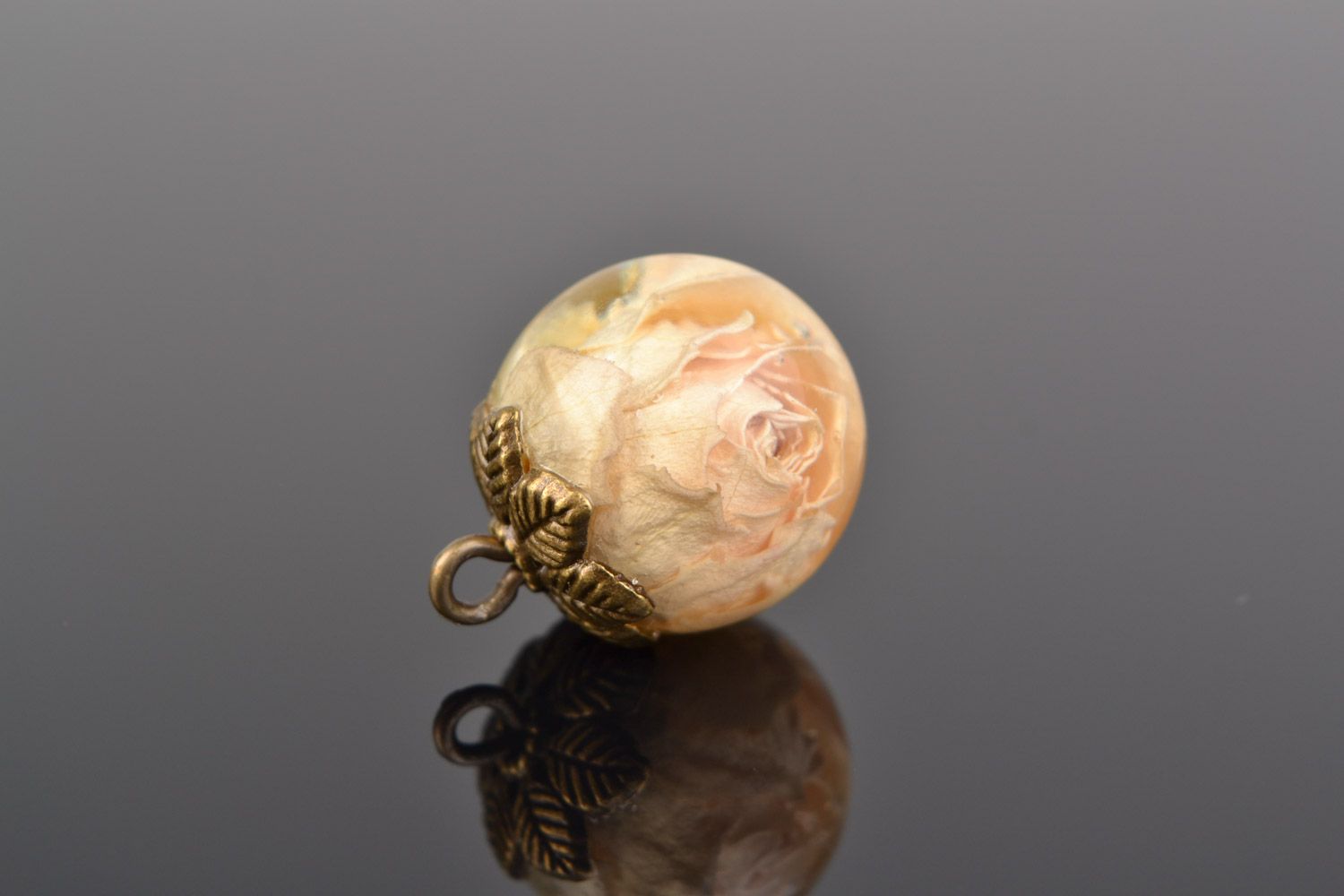 Colgante hecho a mano con rosa cubierta con resina epoxi redondo con forma de bola foto 1