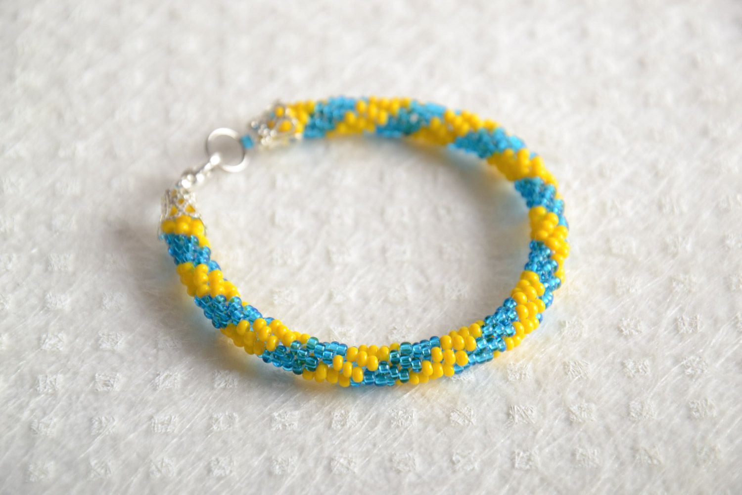 Яркий наручный браслет из бисера ручной работы желтый с голубым в форме жгута фото 1