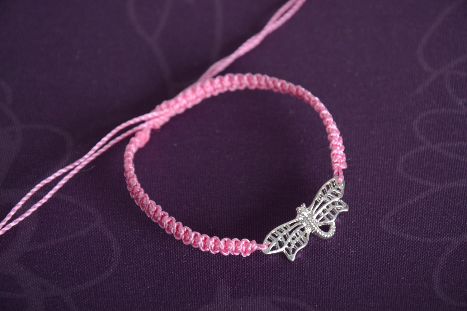 Handmade pink women's woven capron thread bracelet with metal charm in the shape of butterfly photo 1