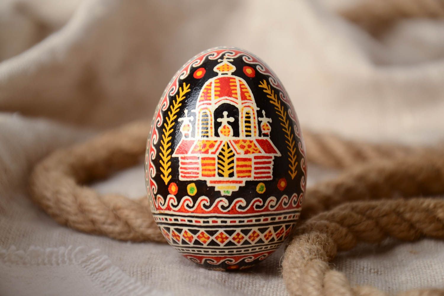 Handmade decorative painted Easter egg with black background and church image photo 1