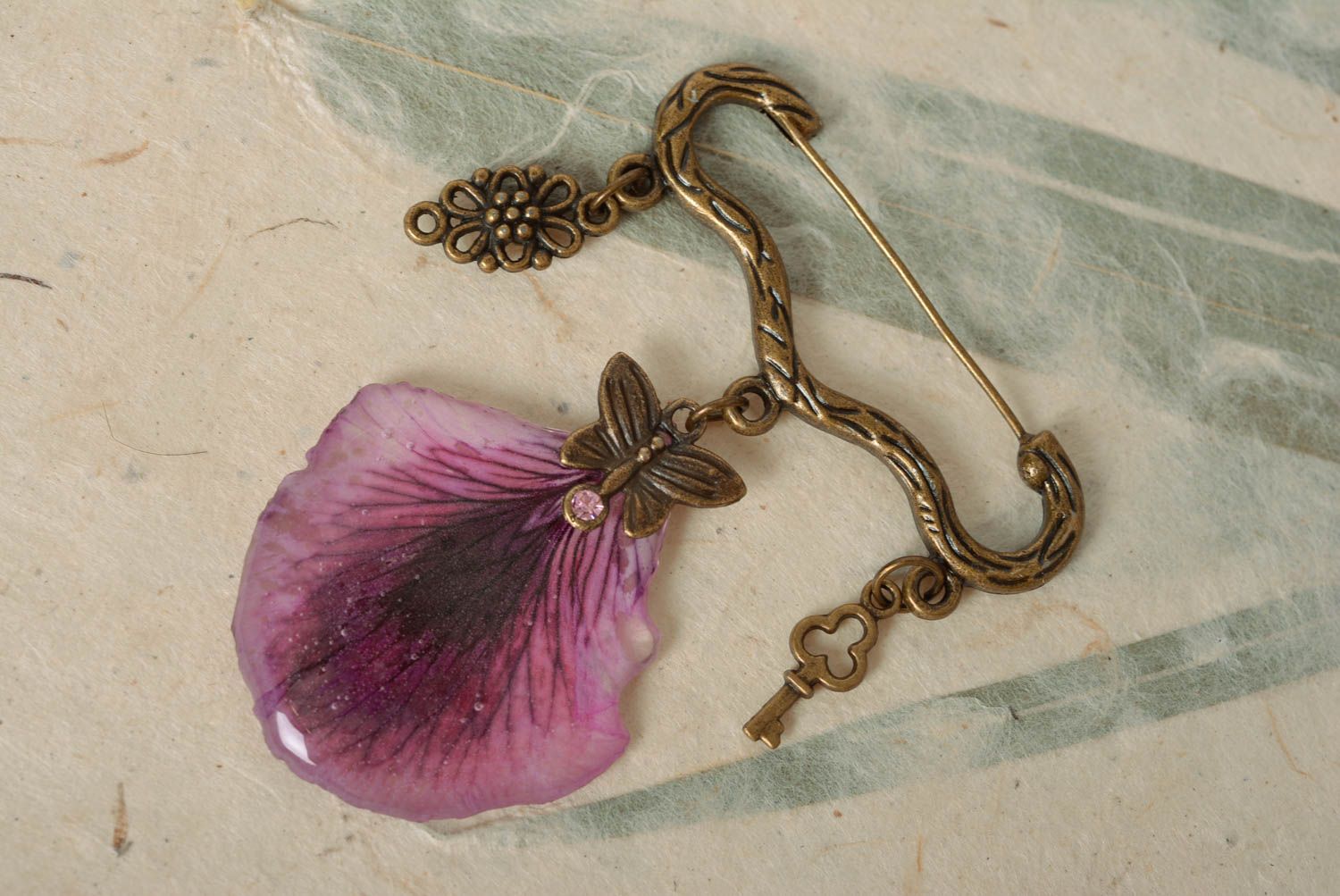 Handmade designer metal figured pin brooch with violet petal in epoxy resin photo 1