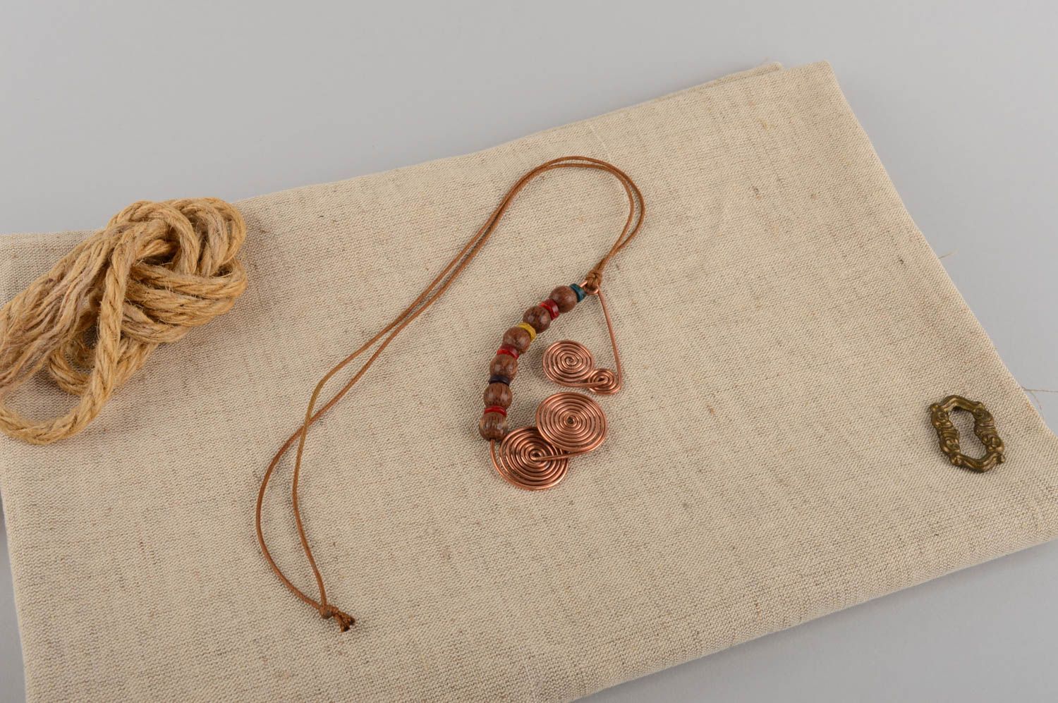 Pingente feminino artesanal feito de cobre e madeira em uma corda foto 1