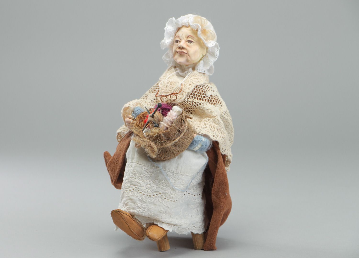 Handmade figurine molded of clay Granny in bonnet sitting in wooden arm chair photo 1