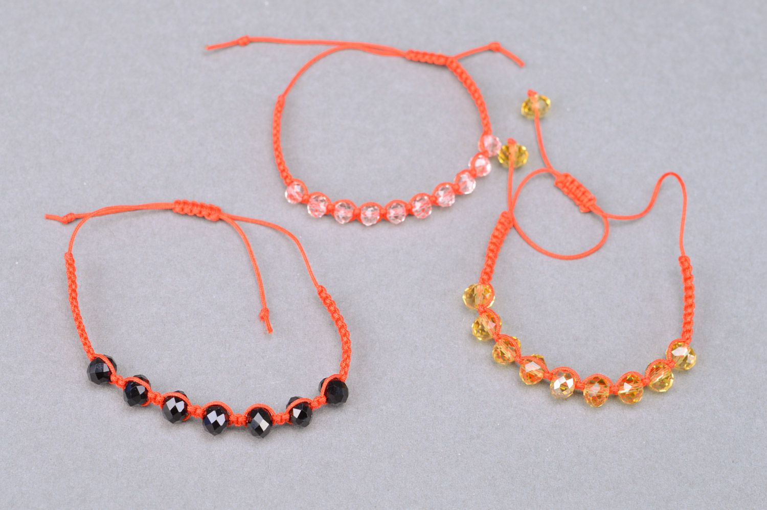 Trois bracelets tressés de fils rouges et perles fantaisie faits à la main photo 2