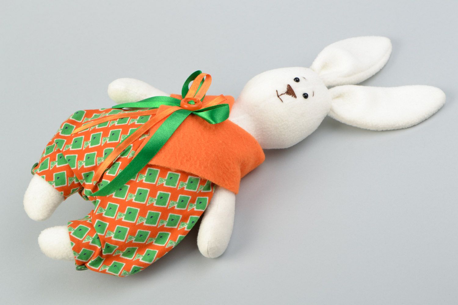 Juguete de peluche artesanal de forro polar conejo con lazo en traje festivo foto 1