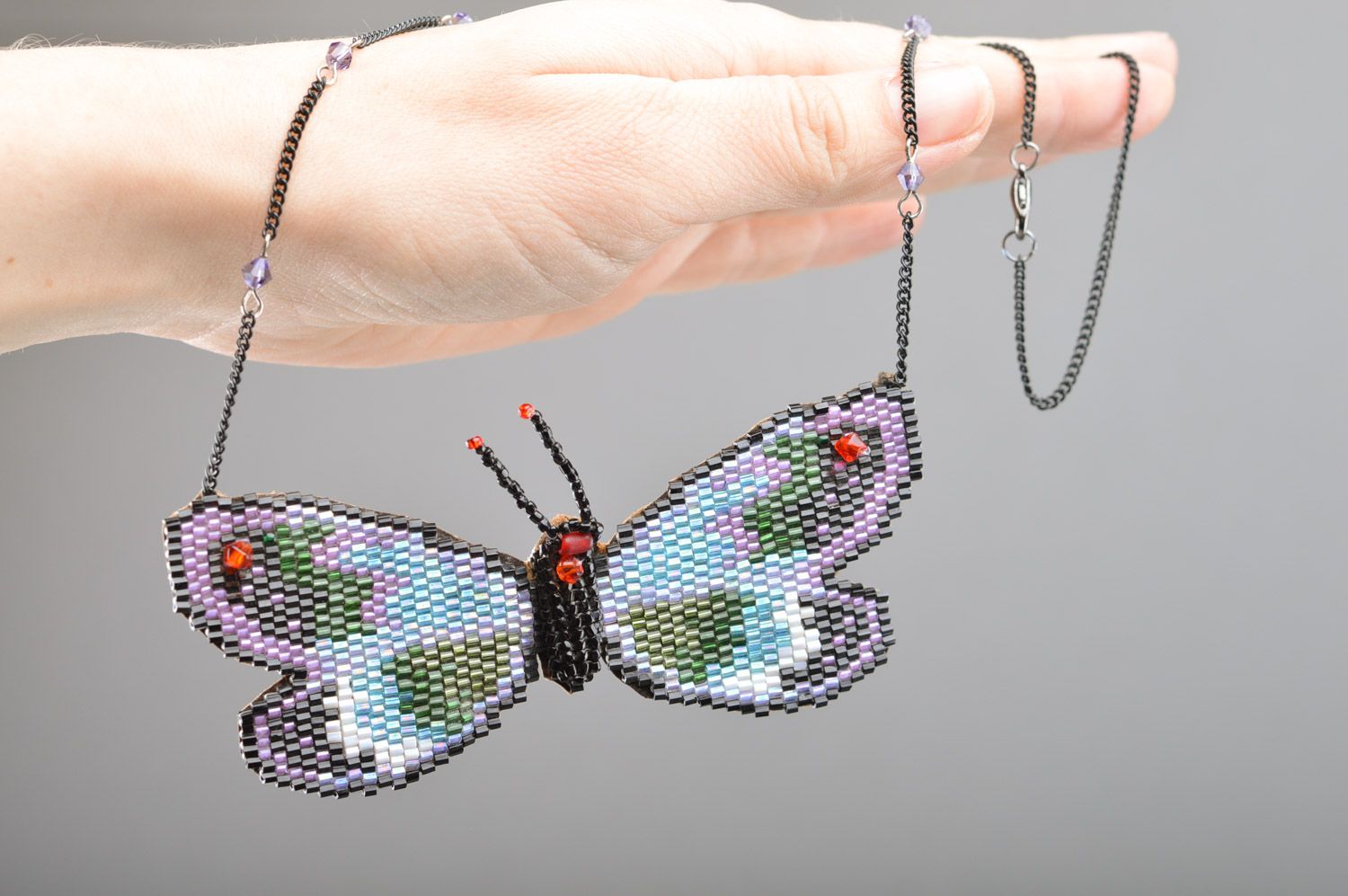 Langer handgemachter Anhänger aus Glasperlen in Form vom Schmetterling foto 5