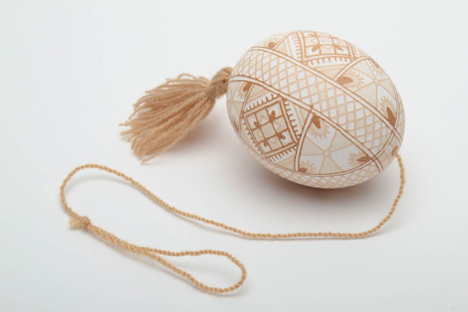 Handmade decorative light beige painted egg with geometric ornaments and tassel photo 2