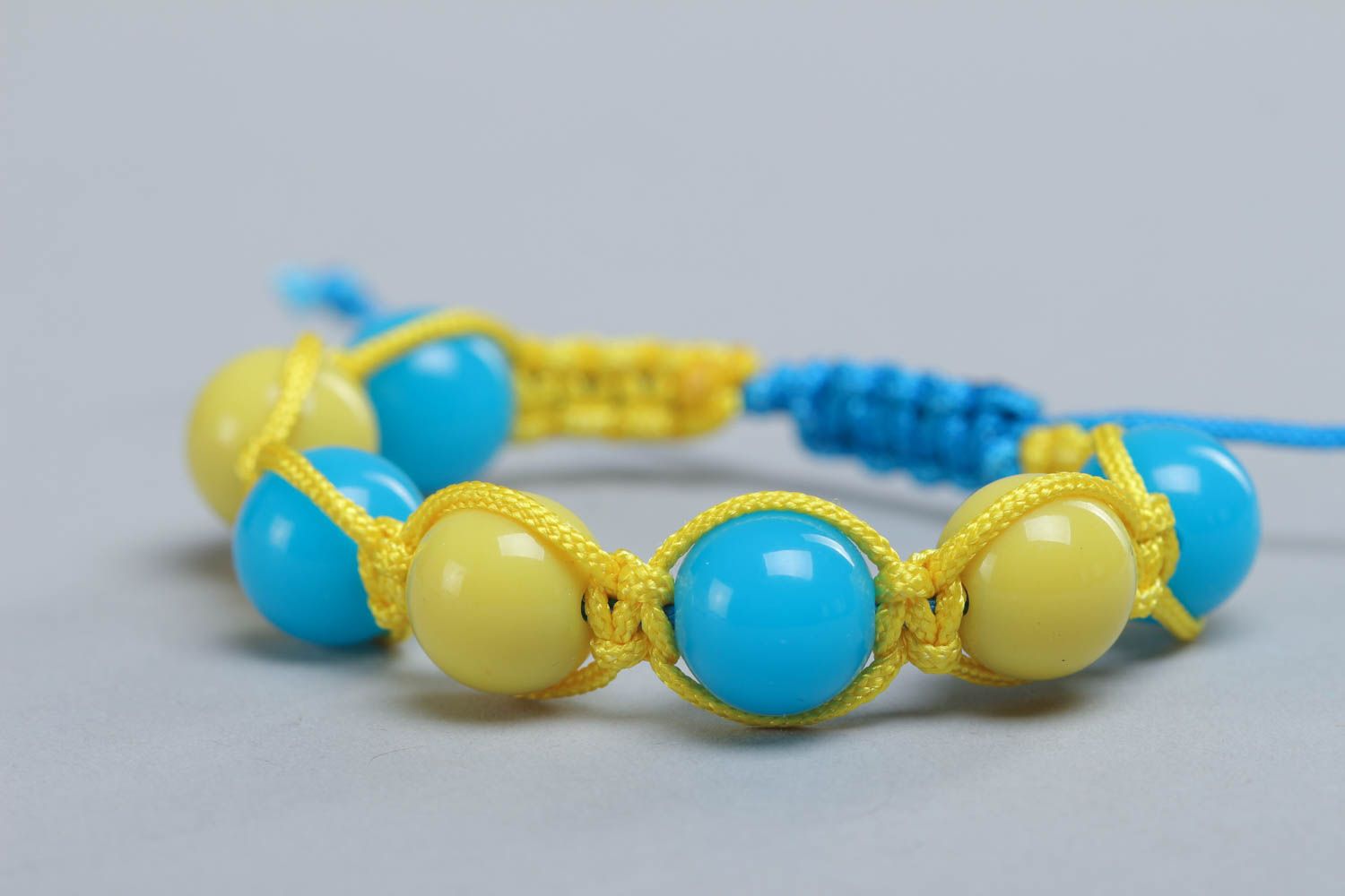 Bracelet en fils et perles plastiques tressé jaune et bleu fait main pour femme photo 3
