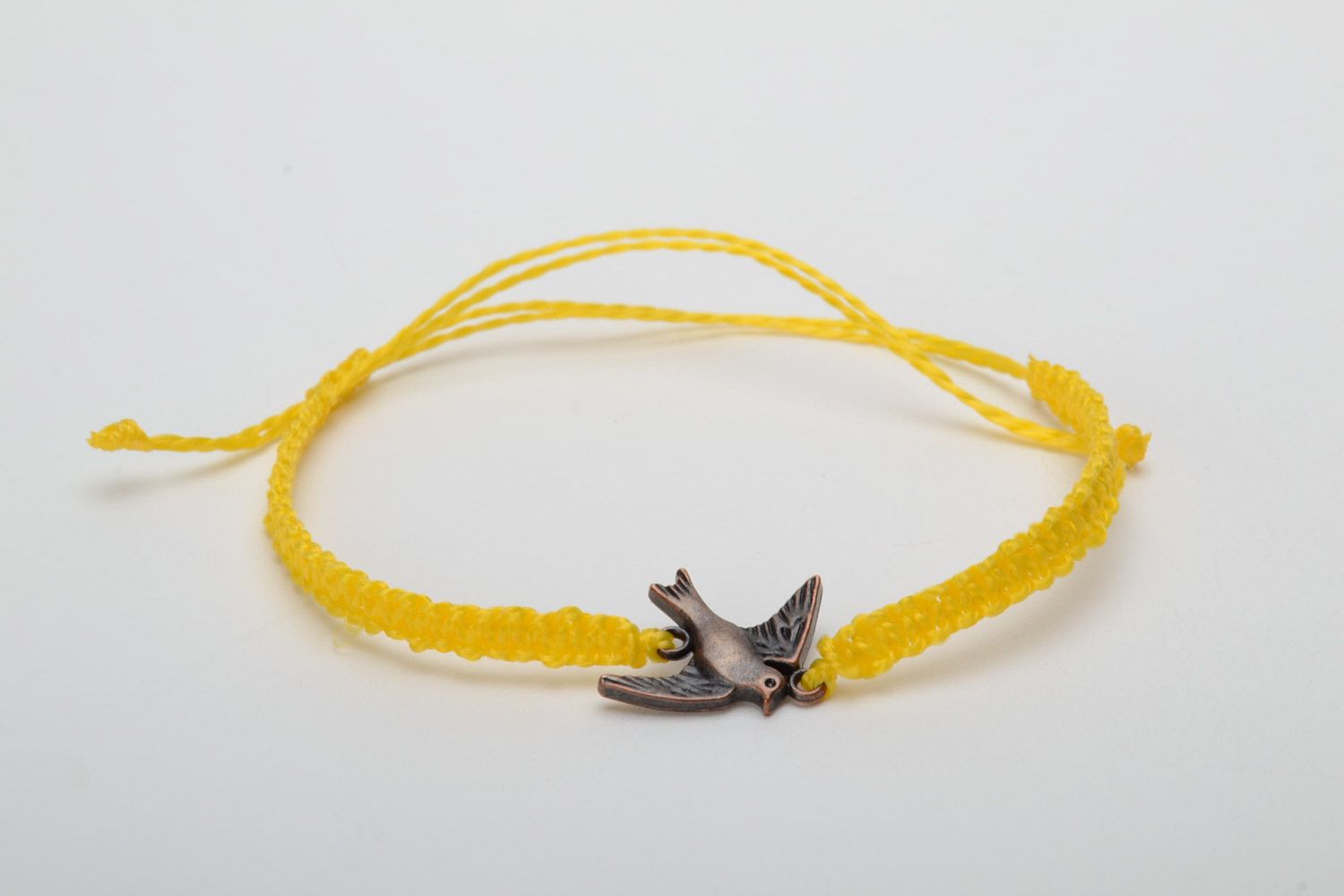 Handmade women's woven capron thread wrist bracelet of yellow color with metal bird charm photo 5