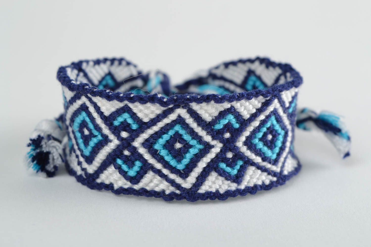 Handmade macrame bracelet woven of white and blue embroidery floss with ornament photo 3