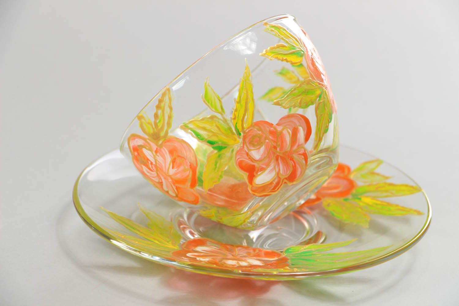 Clear glass tea cup with handle, saucer, and red and yellow flower pattern photo 2