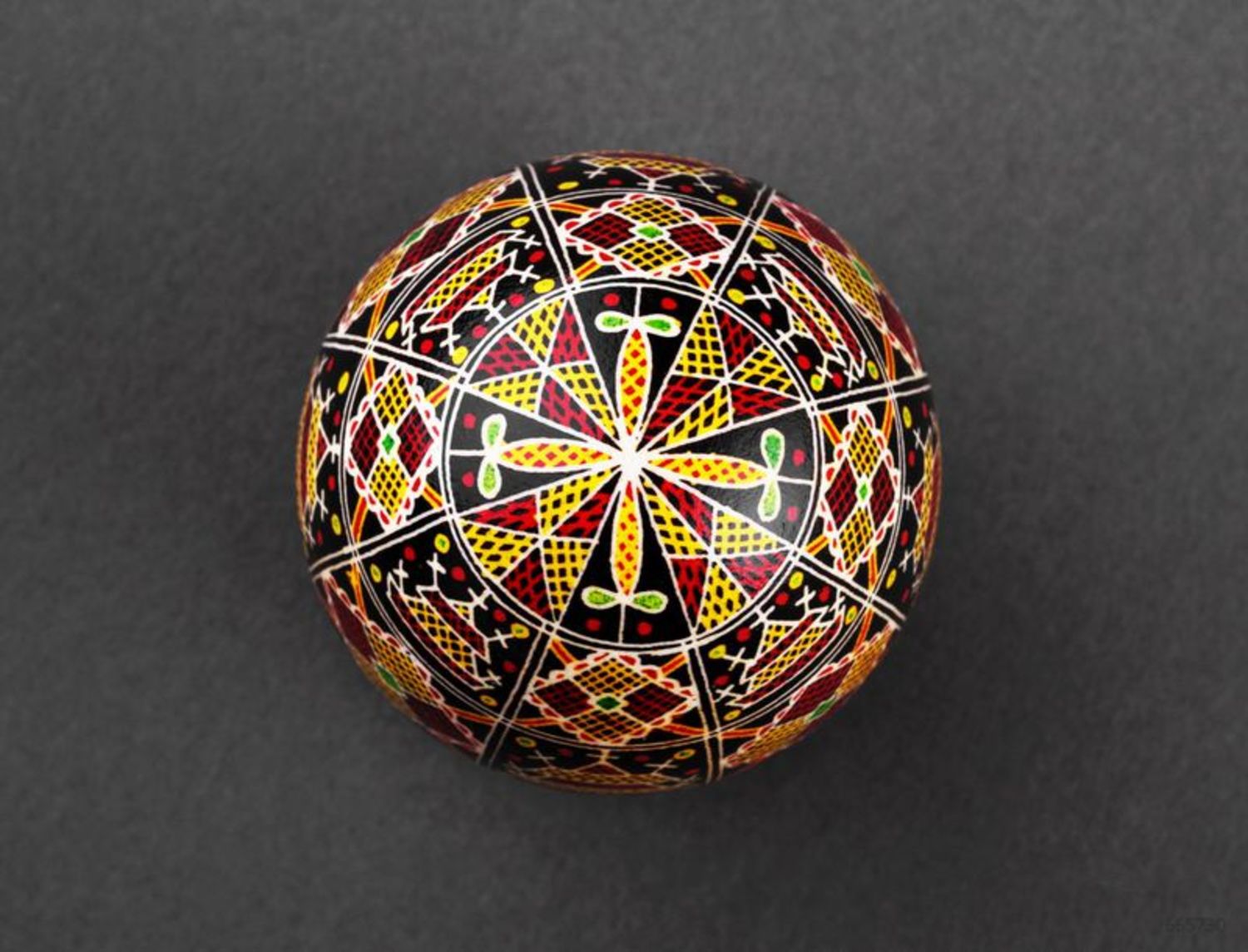 Black pysanka with red and yellow ornament photo 4