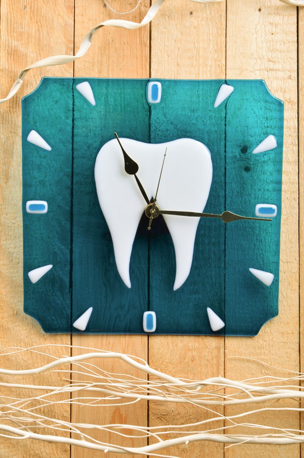 Reloj de cristal en técnica de vitrofusión artesanal diente en fondo azul para estomatología foto 1