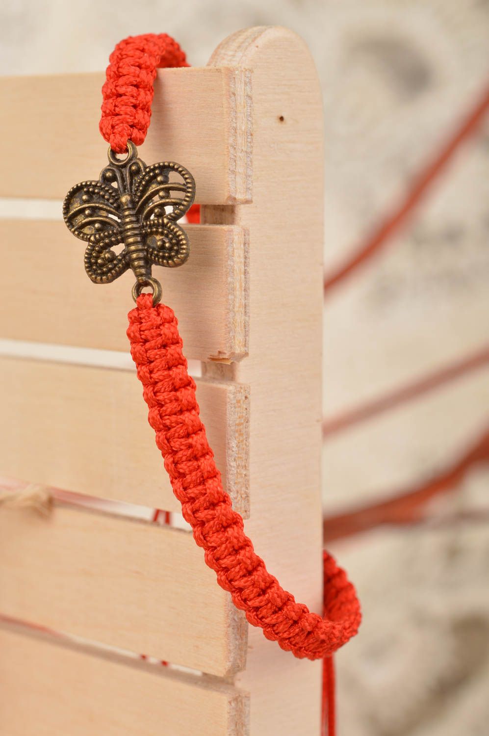 Handmade stylish red woven wrist bracelet made of threads with butterfly photo 1