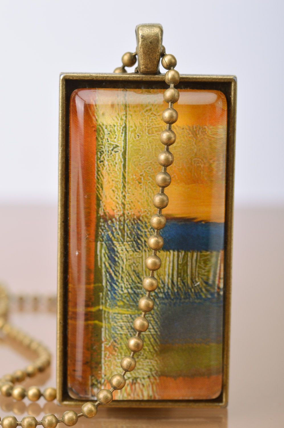 Handmade rectangular metal pendant in warm colors on long chain of bronze color  photo 4