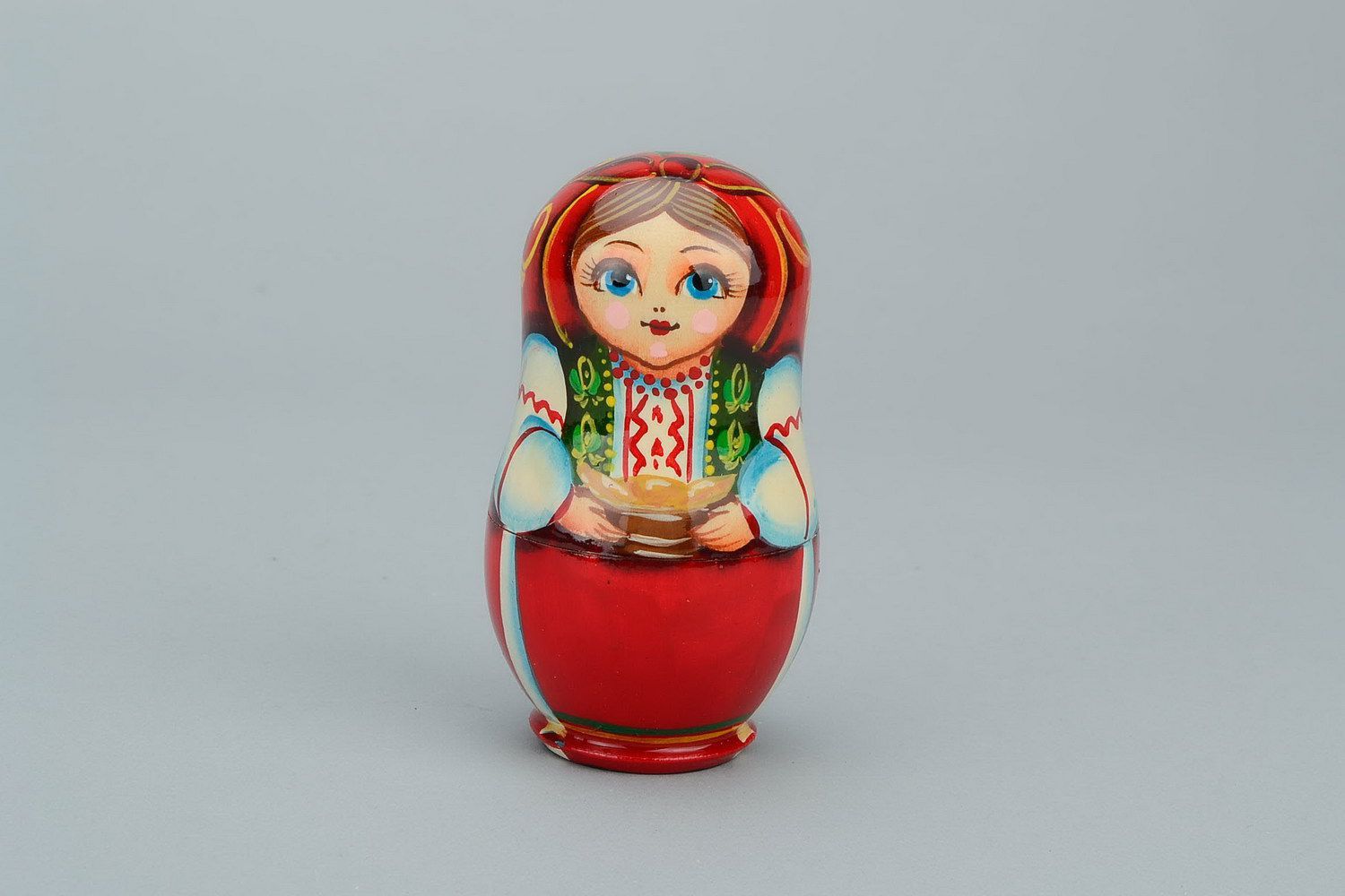 Matrioshka en una ropa nacional ucraniana con varéniki. Matrioshka es la muñeca de madera con vestido ruso campesino, que contiene otras de menor tamaño. Varéniki es una comida nacional de Ucrania
 foto 1