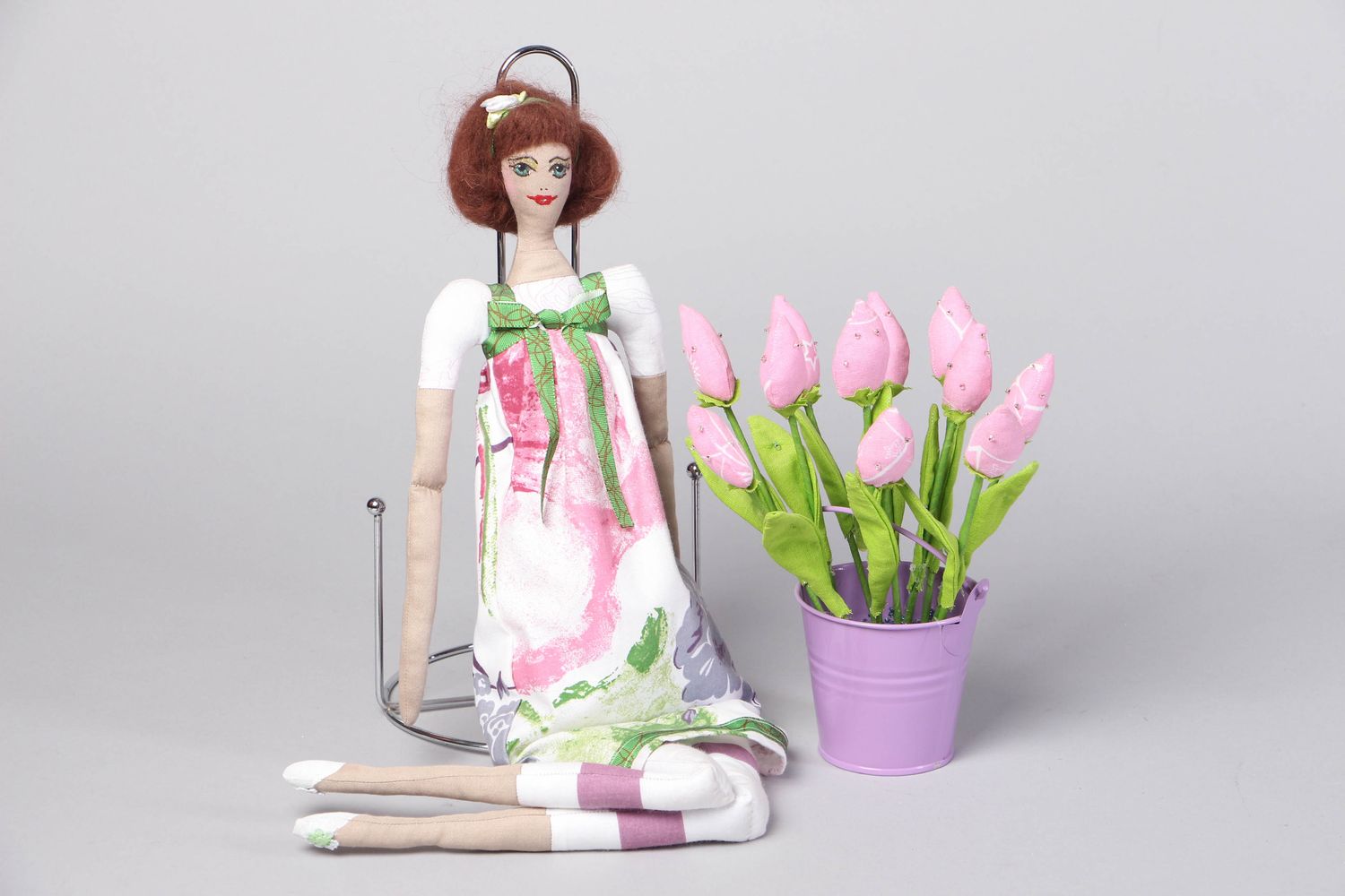 Muñeca de tela artesanal en soporte con flores foto 1