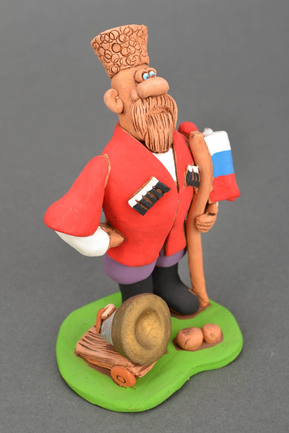 Handgemachte Figurine aus Ton Kosak mit der Kanone und Flagge foto 3