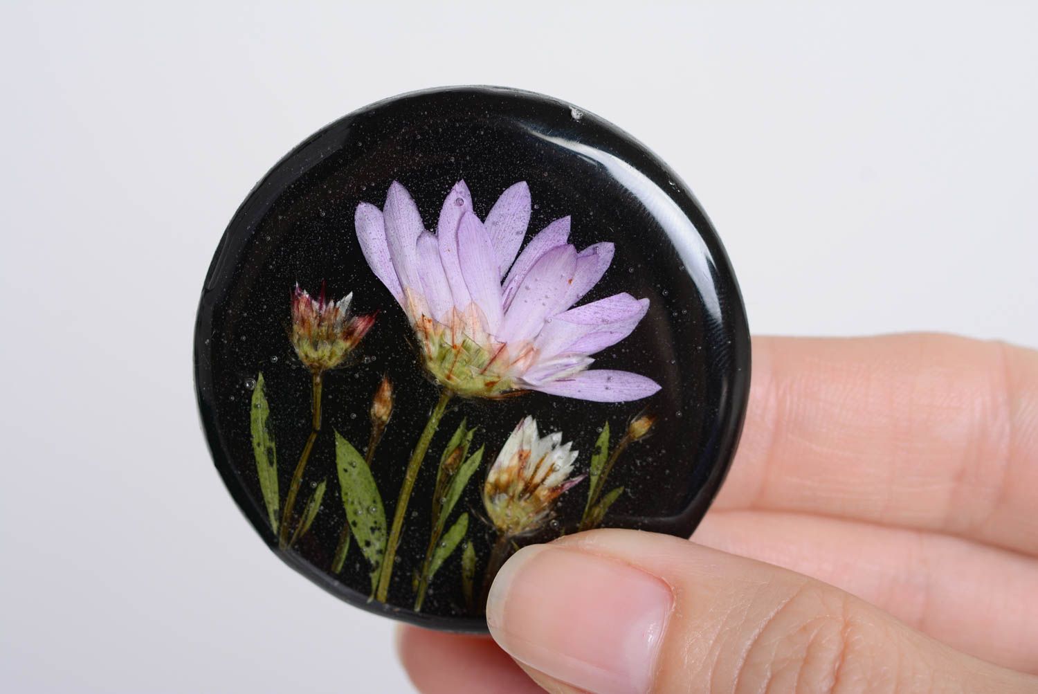 Künstlerische handgemachte Brosche mit Blumen in Epoxidharz rund dunkel handmade foto 4