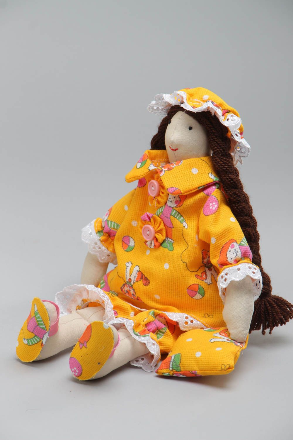 Künstlerische Puppe aus Textil in gelber Kleidung und mit langen Zöpfen handmade foto 2