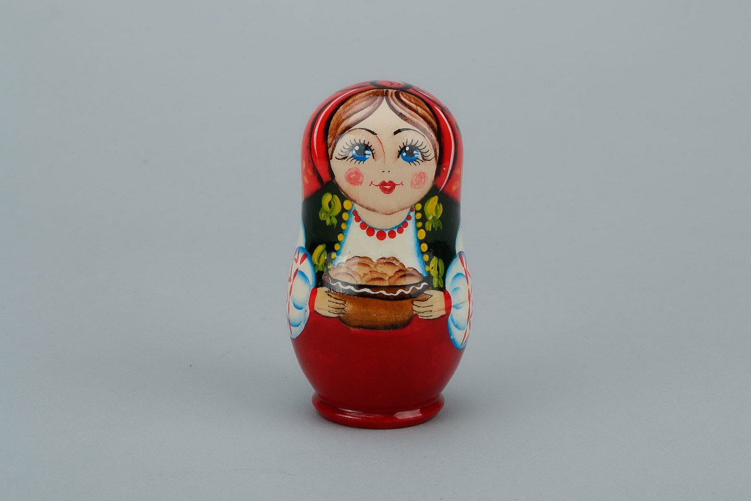Matrioshka en collar con varéniki Matrioshka es la muñeca de madera con vestido ruso campesino, que contiene otras de menor tamaño. Varéniki son pequeñas empanadillas con requesón, boyas u otros ingredientes foto 1