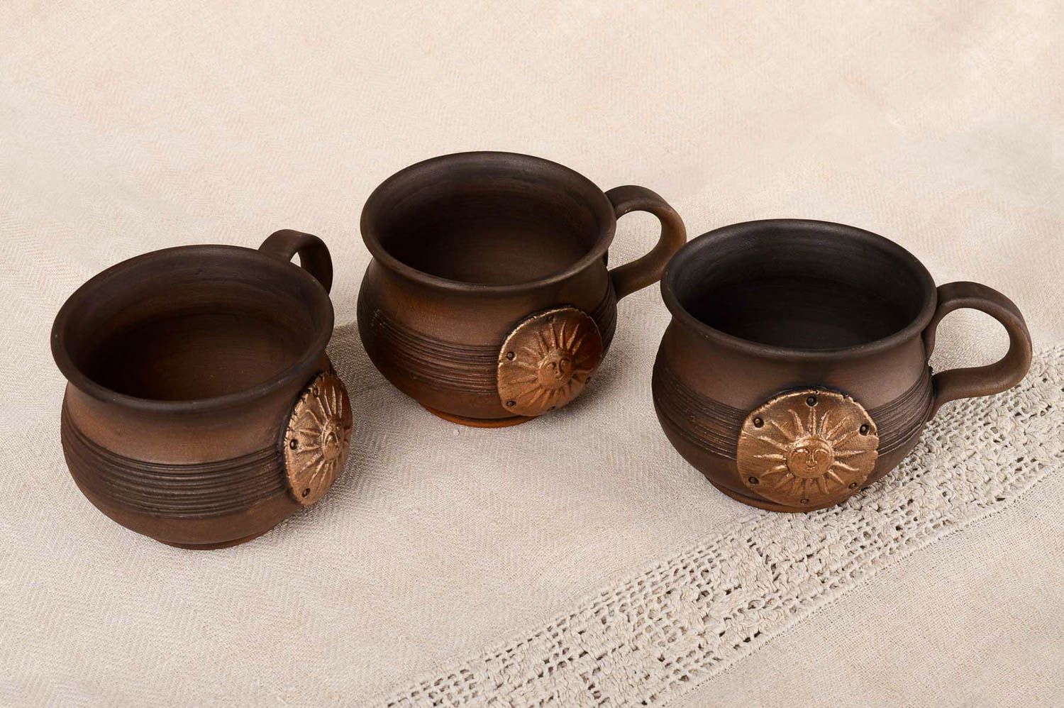Set of 3 three clay coffee cups in dark brown color with molded sun pattern photo 1
