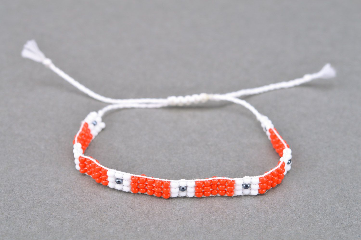 Handmade woven women's thin beaded wrist bracelet of red and white colors photo 2