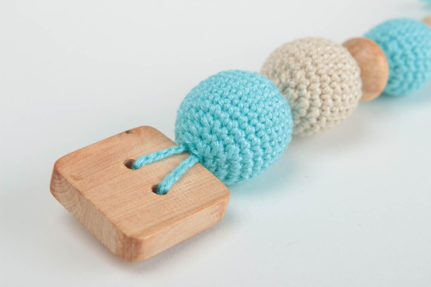 Игрушка прорезыватель для ребенка из дерева и ниток ручной работы голубой фото 3