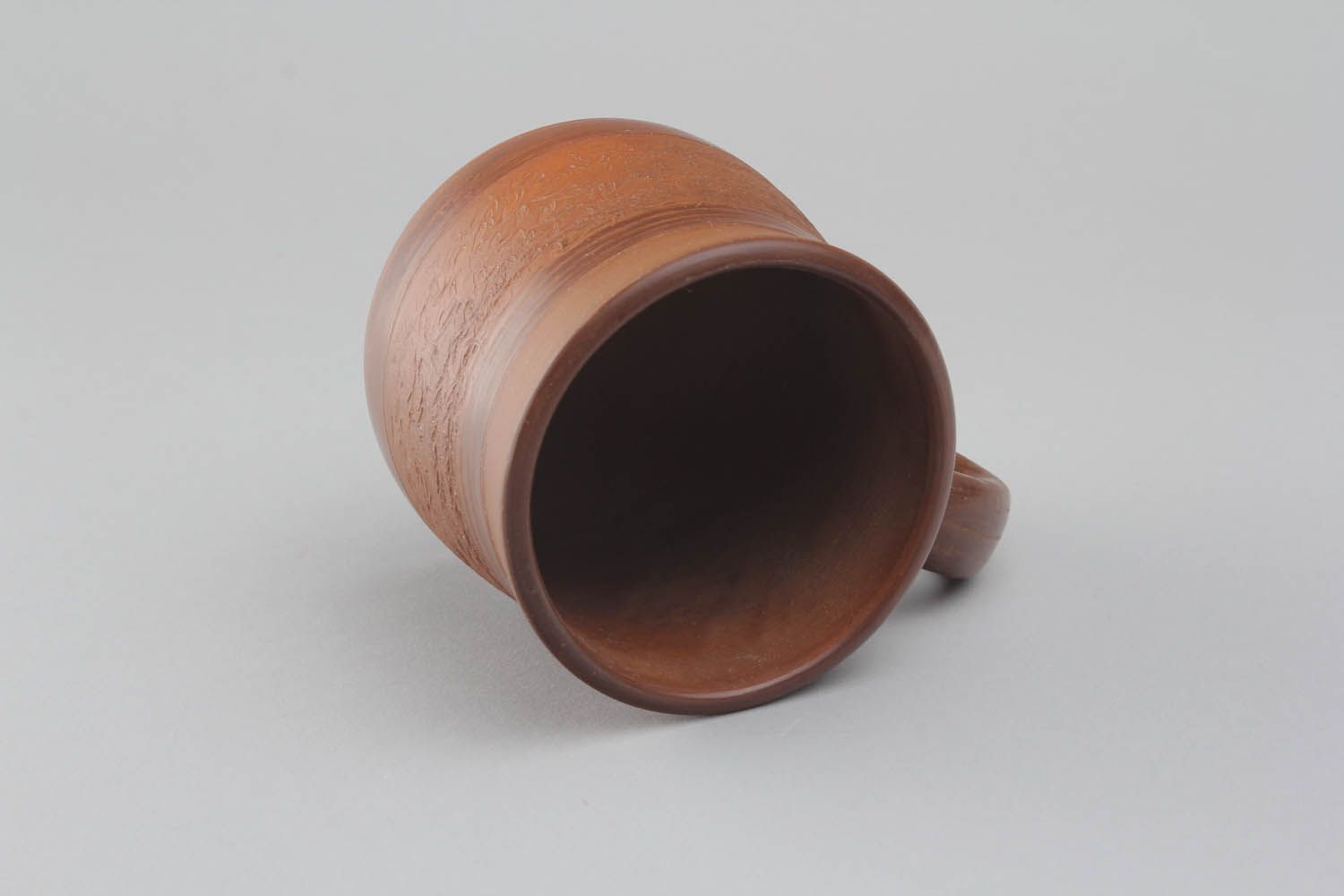 Brown clay coffee mug with handle and no pattern in the rustic shape photo 3