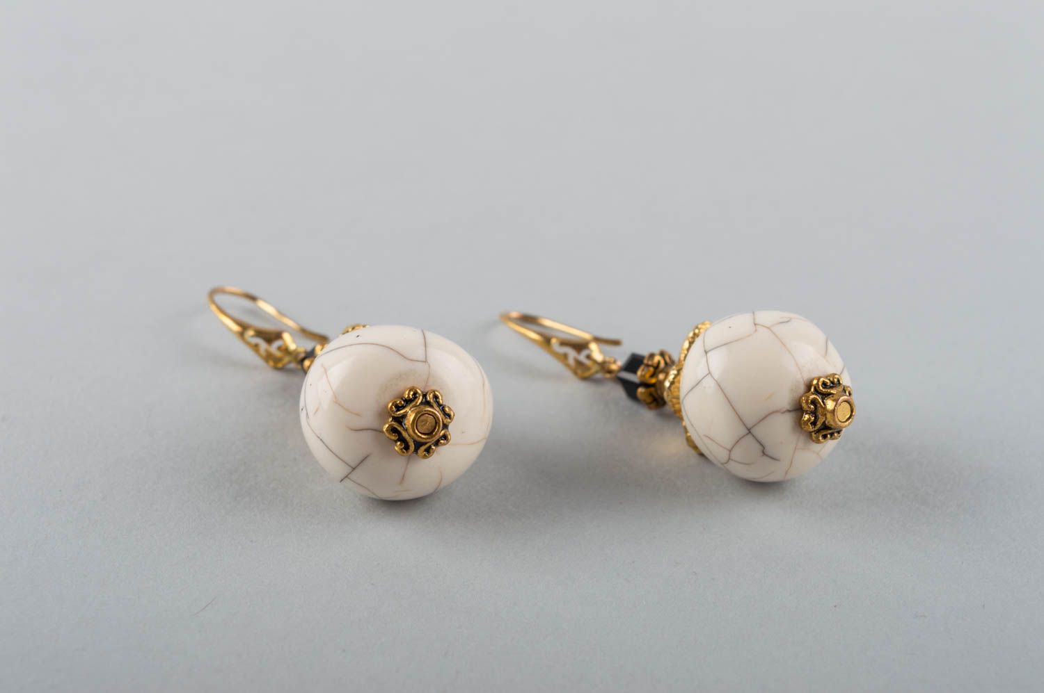 Kleine runde weiße handgemachte Ohrringe mit Anhängern aus Naturstein Gowlit foto 3