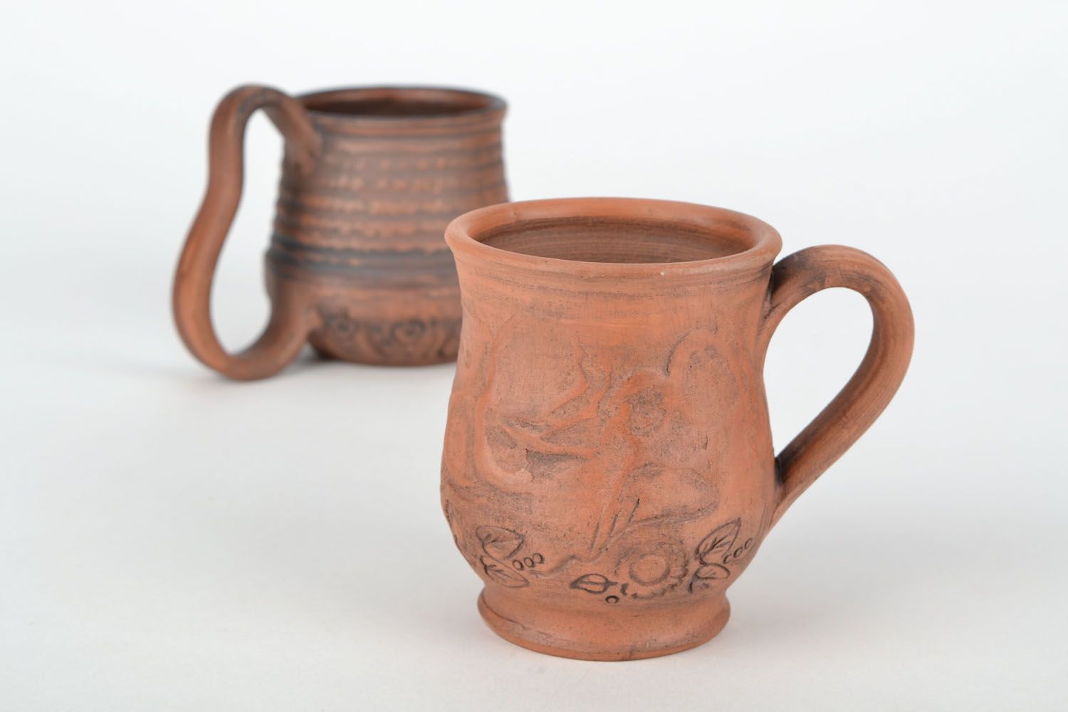 Red clay drinking cup with rustic floral pattern photo 1