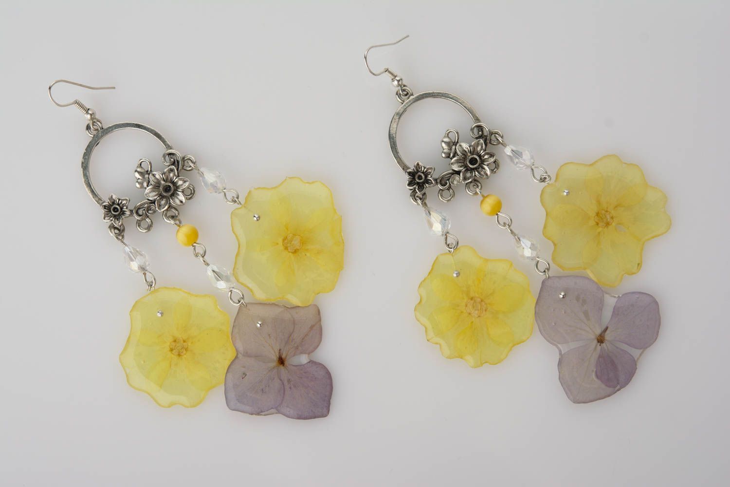Handmade decorative earrings with primrose and hydrangea petals in epoxy resin photo 1