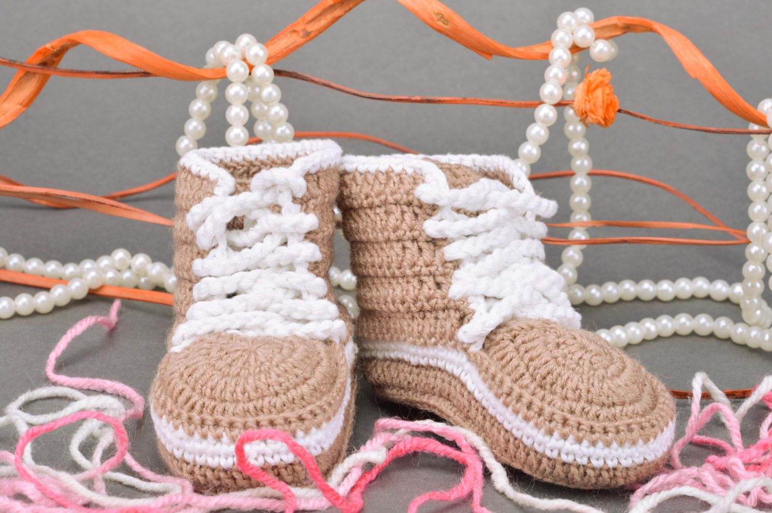 Originelle hellbraune gehäkelte Babyschuhe mit Schuhbändern in Form der Turnschuhen foto 1