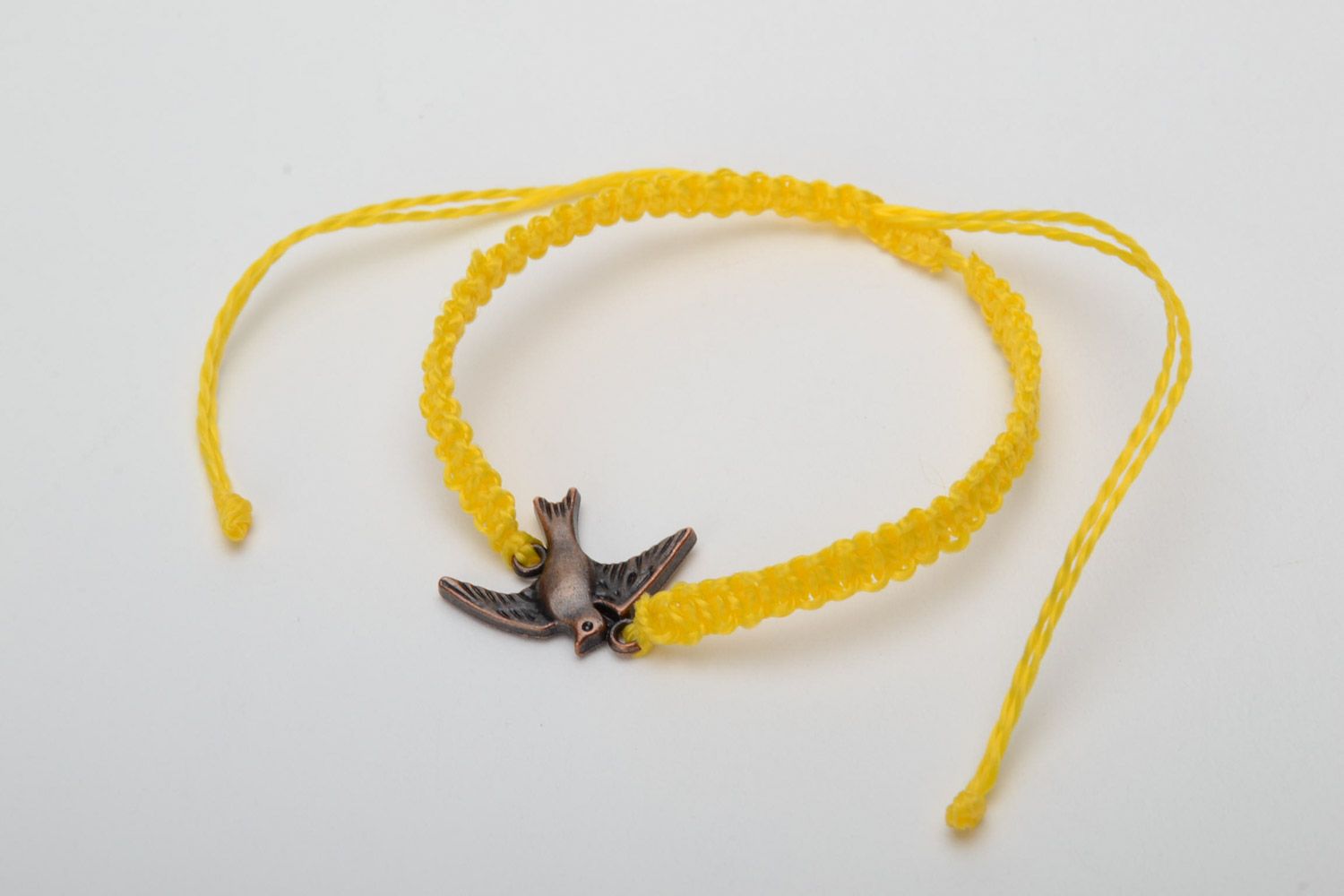 Handmade women's woven capron thread wrist bracelet of yellow color with metal bird charm photo 3