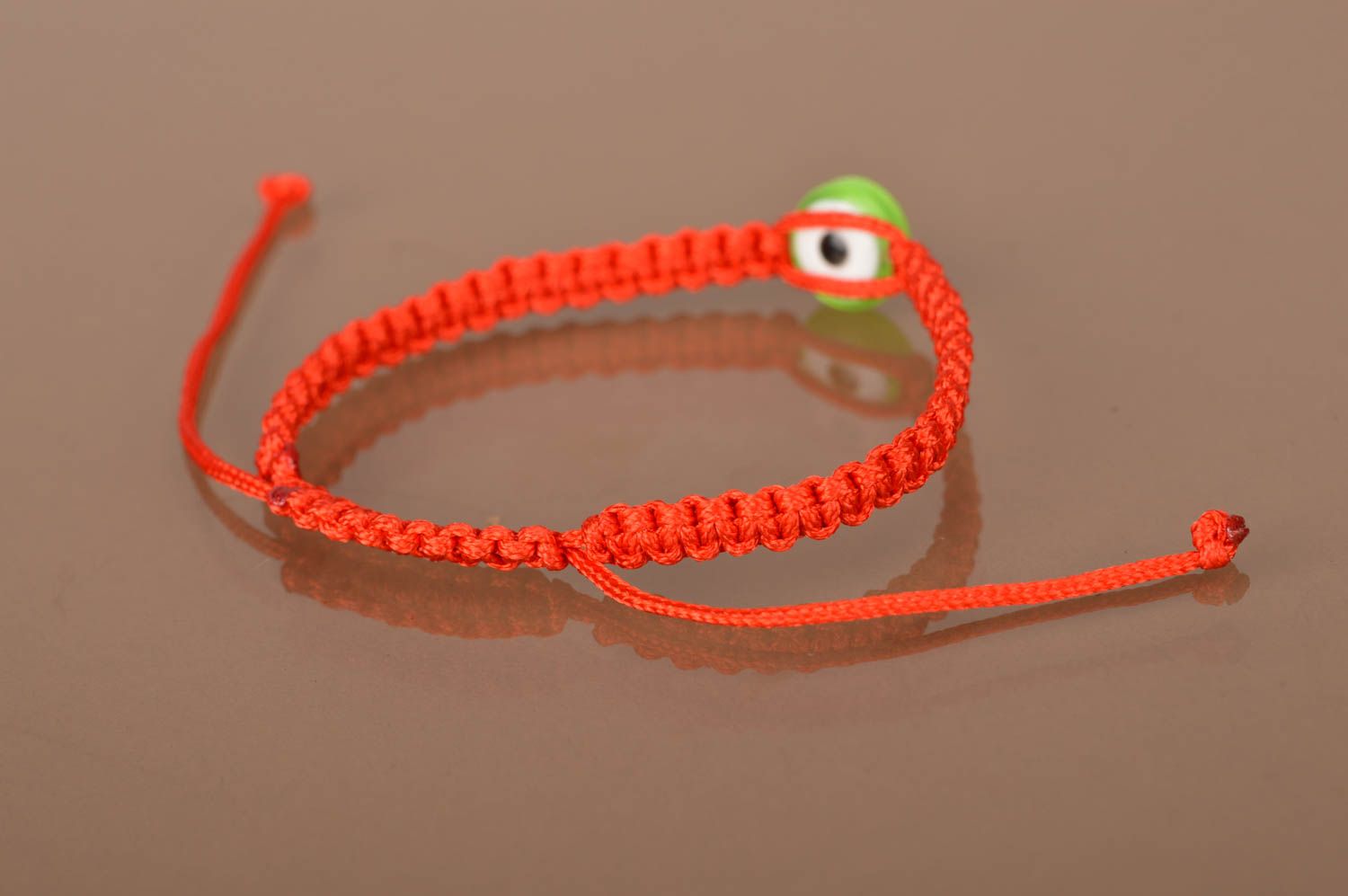 Bracelet fait main pour enfant en lacet ciré rouge tressé fin Œil vert photo 4