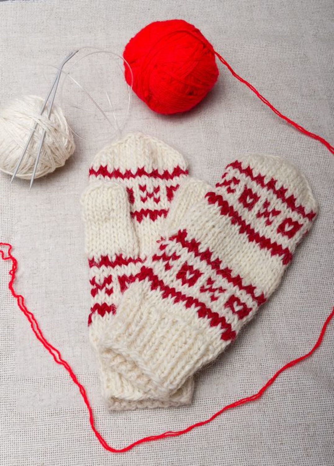 White woolen mittens with red ornament photo 1
