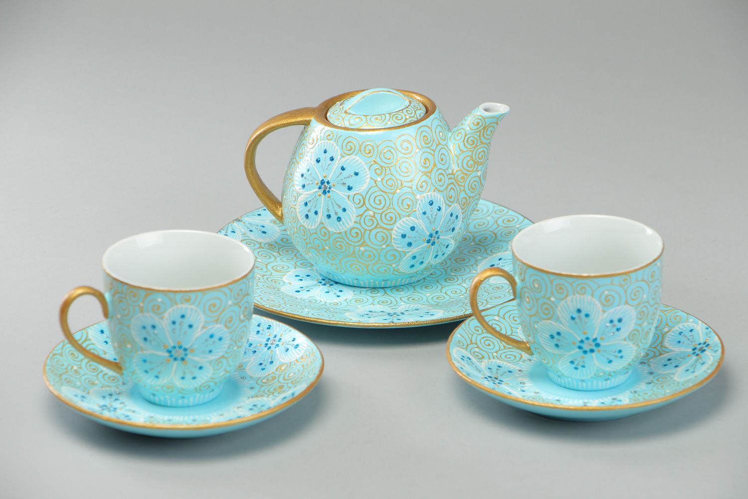 Hand-painted ceramic tea set in blue and gold colors teapot and two cups with handles and saucers photo 1
