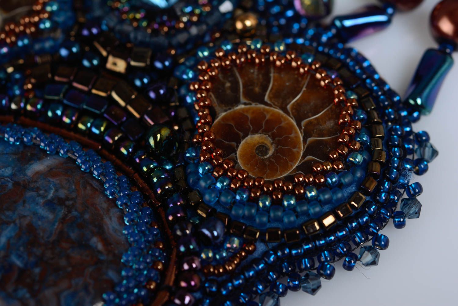 Colgante de abalorios artesanal con piedra natural y amonitas de colores azul y marrón foto 3