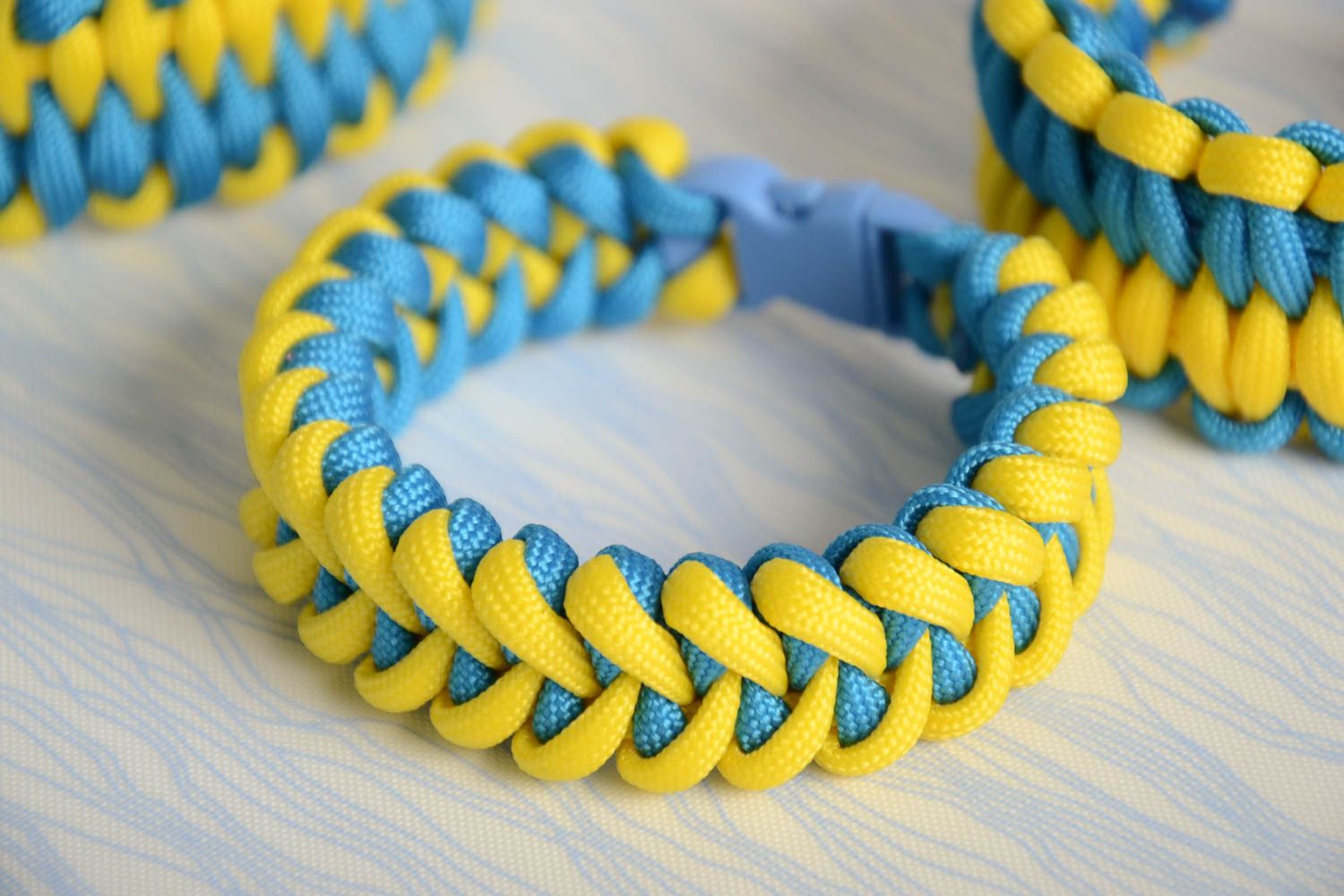 Handmade wrist survival bracelet woven of yellow and blue parachute cords photo 1