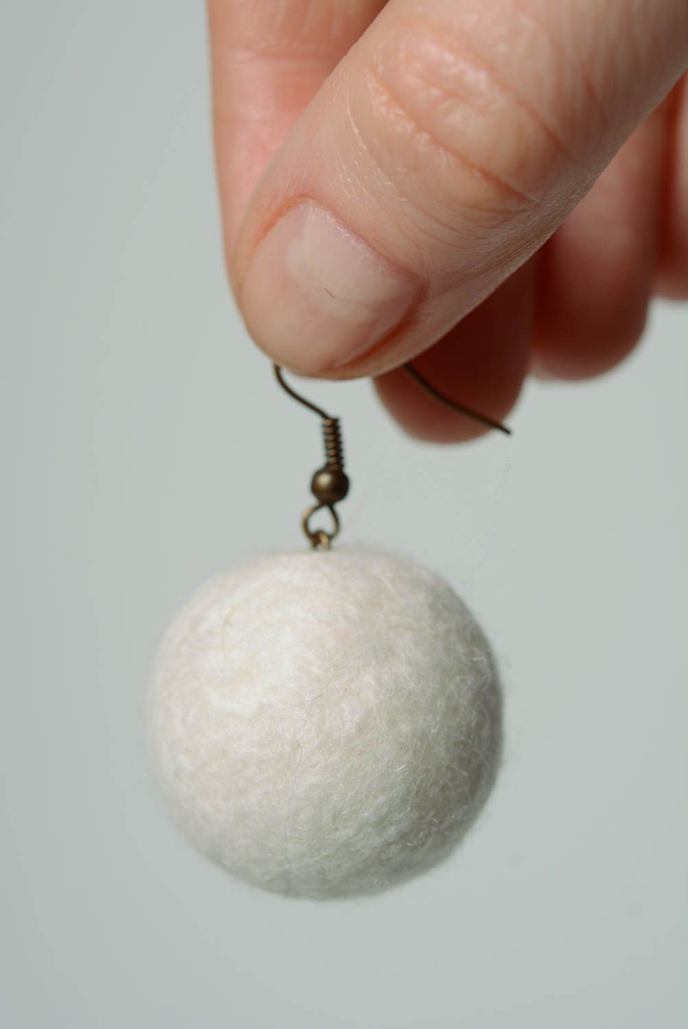 White handmade wool ball earrings created using needle felting technique photo 2