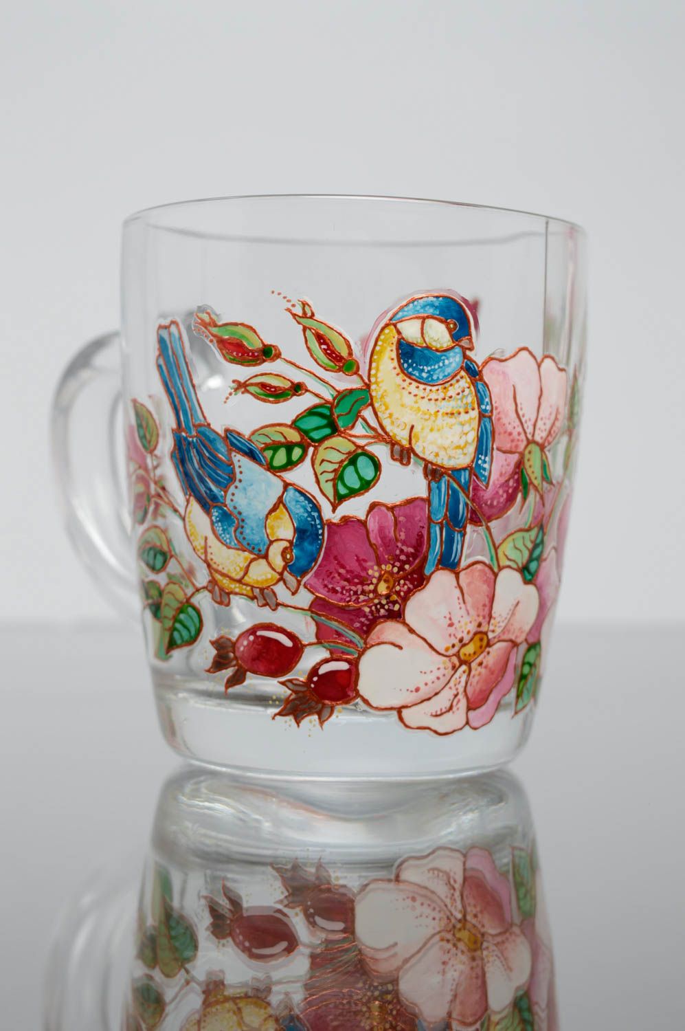 Stained tea cup with handle and hand-painted floral pattern with bird