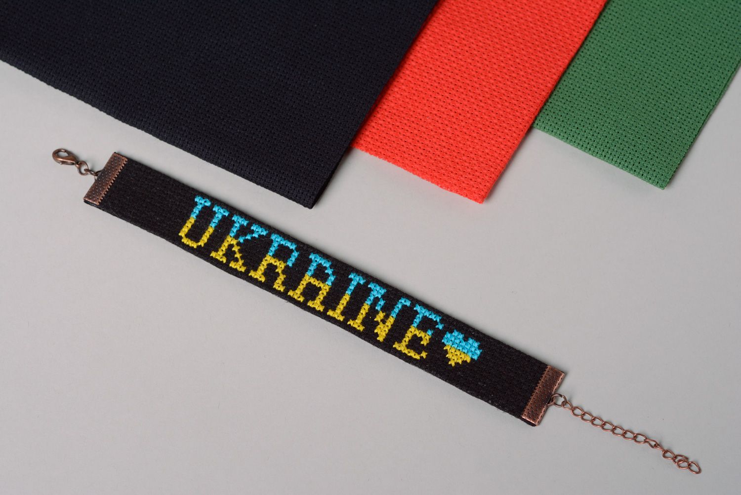 Handmade designer bracelet with embroidered lettering Ukraine on black background photo 1