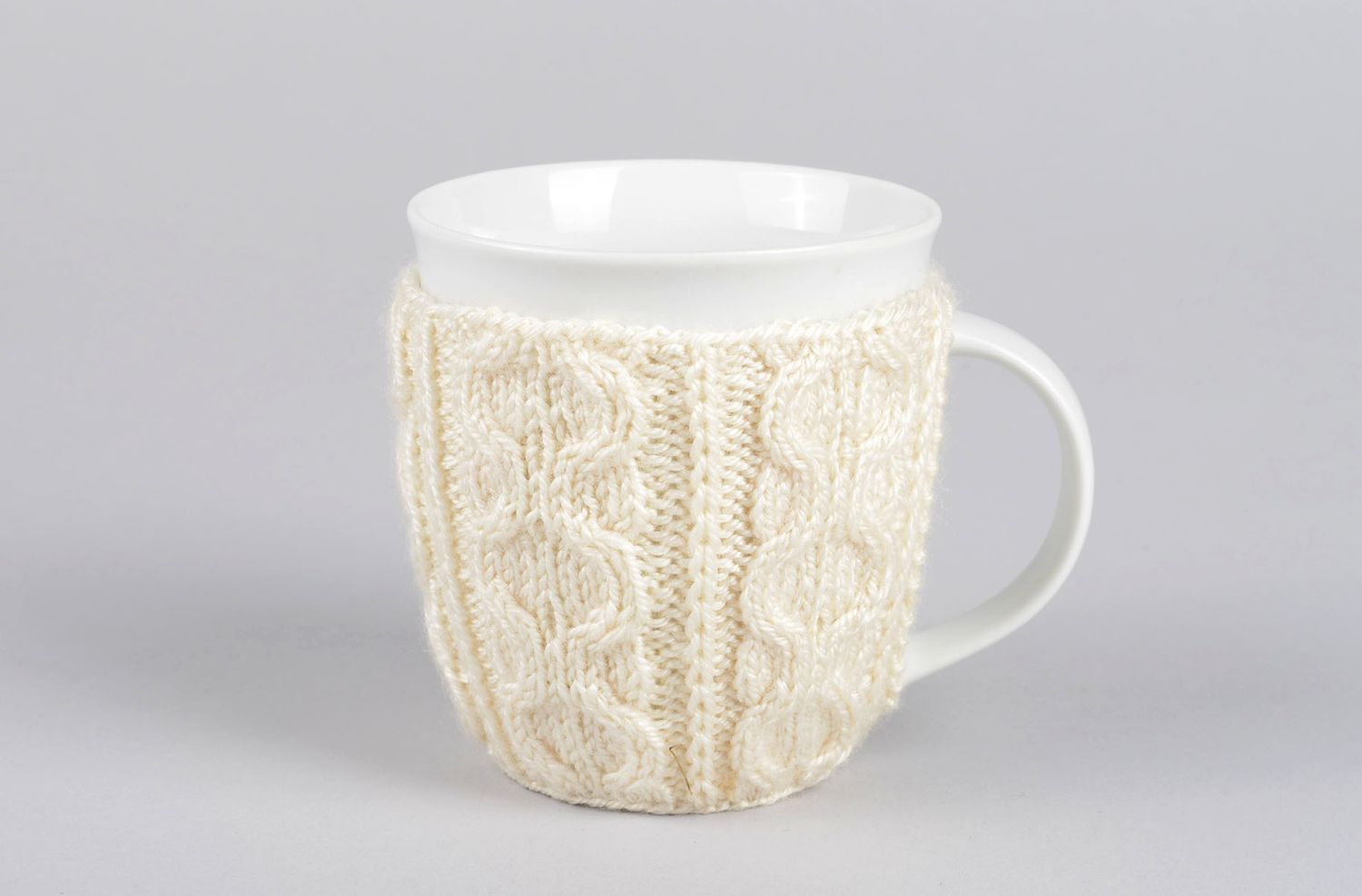 White ceramic porcelain tea or coffee cup with knitted cover with classic pattern photo 2
