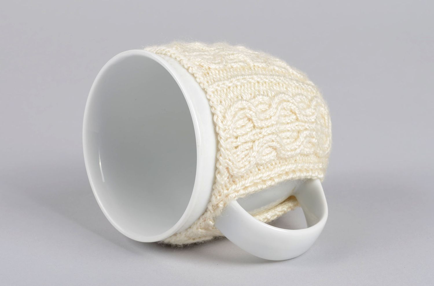 White ceramic porcelain tea or coffee cup with knitted cover with classic pattern photo 3