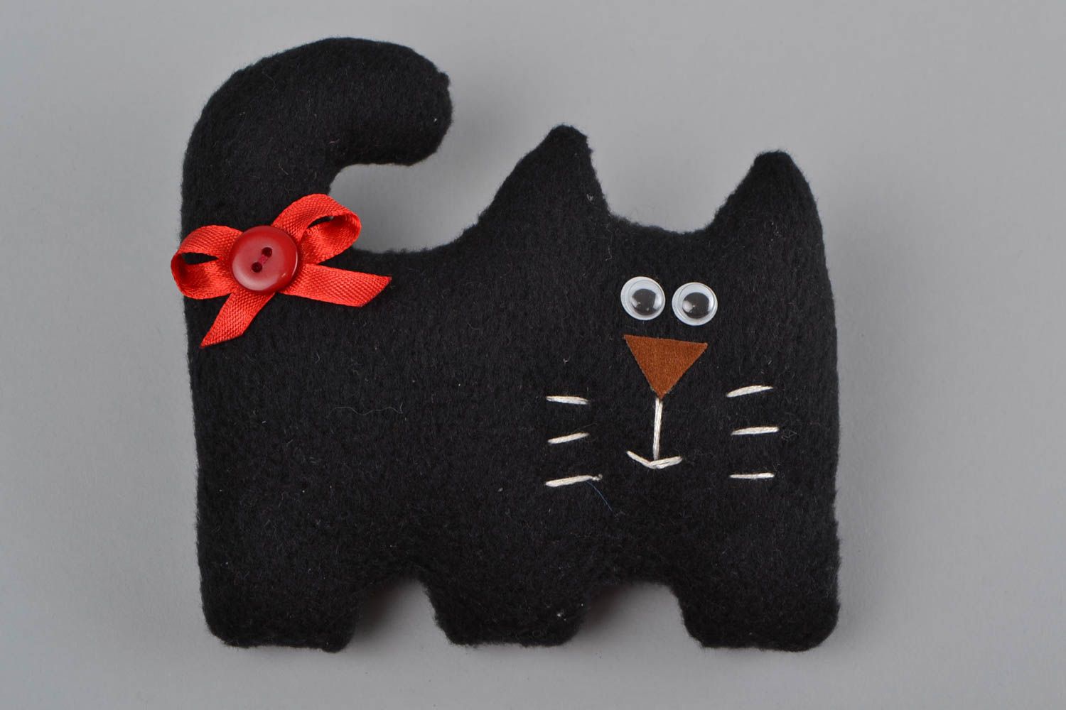 Handmade small soft toy sewn of black fleece in the shape of cat with red bow photo 3